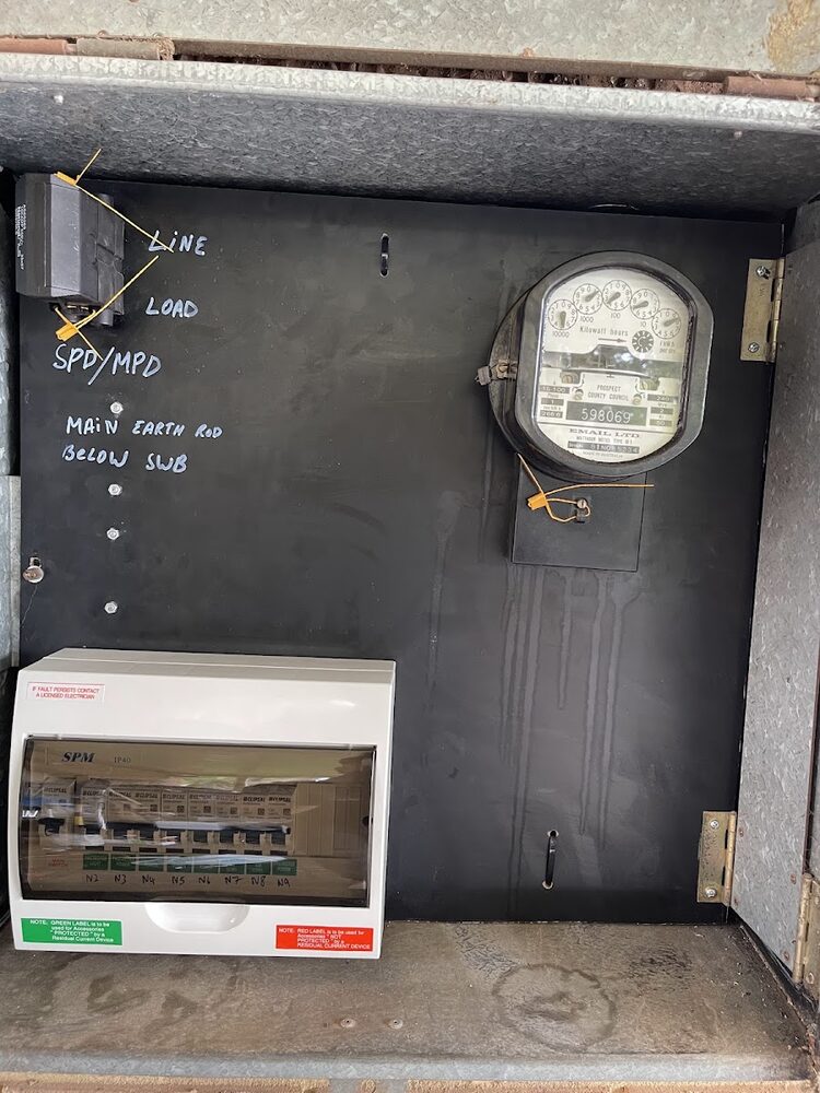 Upgraded meter panel with a new breaker enclosure, terminations marked up in chalk pen